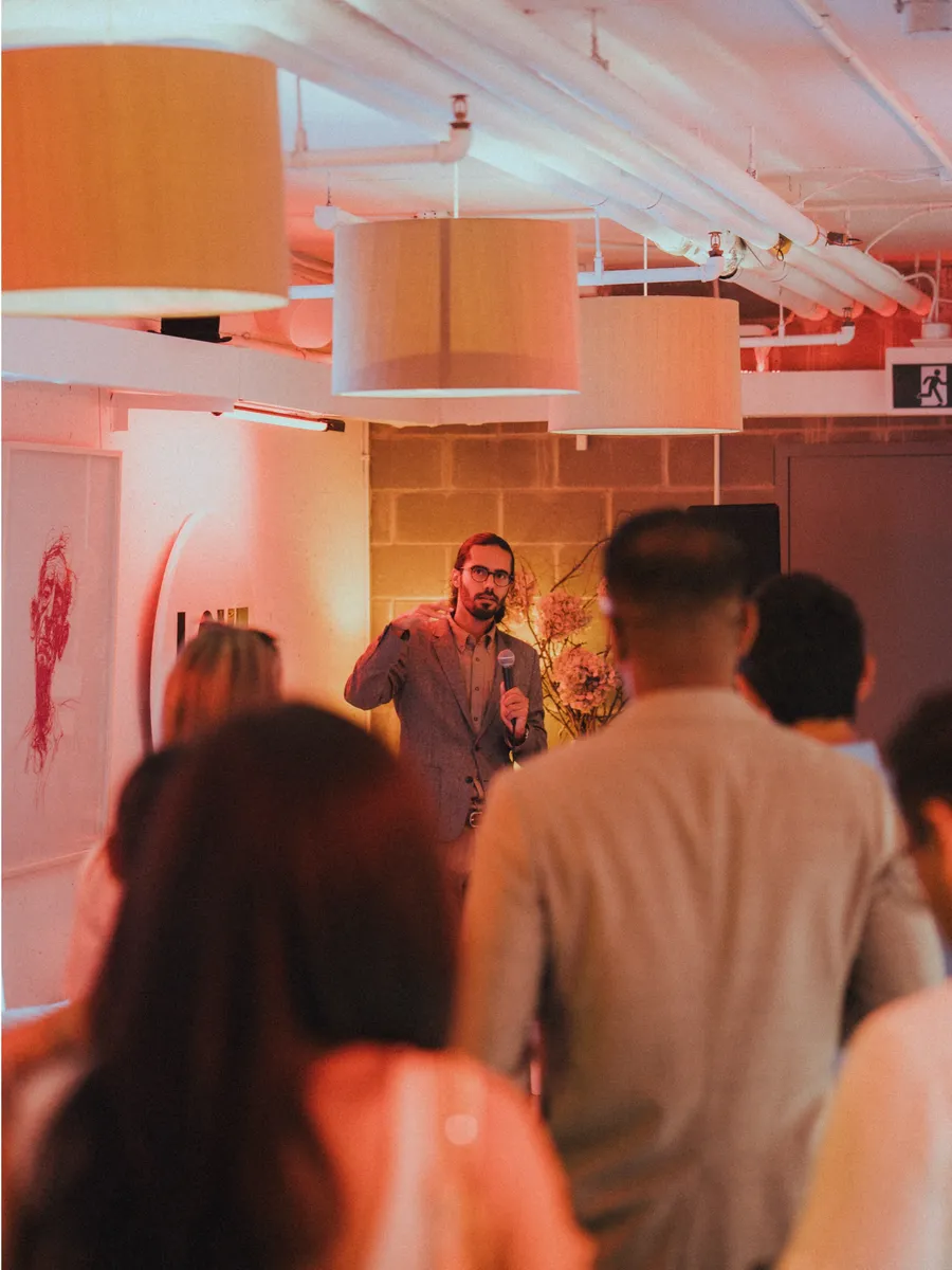 A speaker with a microphone addressing members at the Founder Feast July 30 gathering in Vancouver